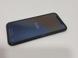 the back of a black phone sitting on top of a white table