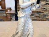 a statue of a woman that is standing on a table