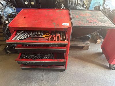 un établi rouge sur lequel sont posés des outils, dans un garage