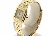 an image of a gold wrist watch on a display stand