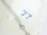 a white bowl with a metal wire on top of it