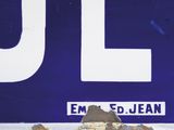 a close up of a blue and white sign on a brick wall