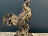 statue of a rooster on a pedestal on a marble table
