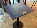 tables and chairs in a room with a sign on the table