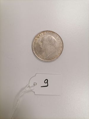 a close up of a coin on a white surface with a price tag