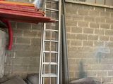 une échelle appuyée contre un mur de briques, à côté d'un tas d'oreillers