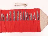 un rouleau rouge sur lequel sont posés des couverts, ainsi qu'un couteau et une fourchette