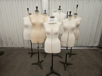 Quatre mannequins sont alignés sur des socles dans une pièce