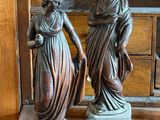 deux statues posées sur une table en bois