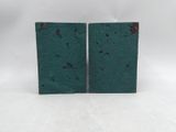 a pair of green concrete blocks sitting on top of a white surface