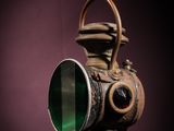 photograph of an old gas mask with a green lens on a purple background