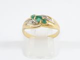 a close up of a gold ring with two emerald stones