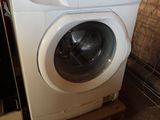 une machine à laver qui se trouve dans le coin d'une pièce