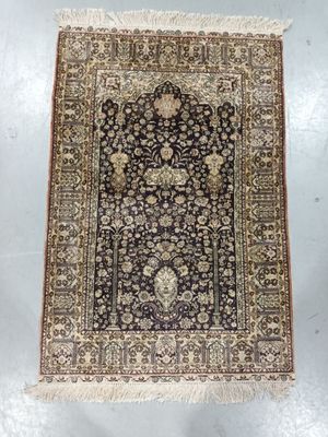 a black and beige rug with a floral design on it