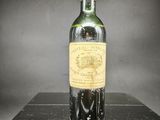 une vieille bouteille de vin posée sur une boîte noire