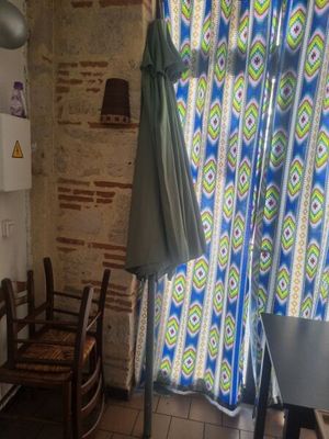 a kitchen with a table, chairs, and an umbrella hanging from the ceiling