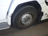 a white truck with a flat tire parked in a parking lot