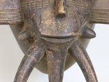 sculpture of a face on a stand on a white surface