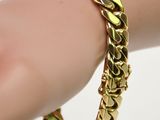 un gros plan sur la main d'une personne portant un bracelet en or