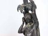 a statue of a woman holding a bird on her head