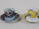 two cups and saucers sitting on a table