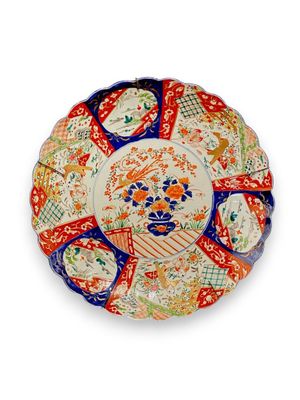 Grand plat à bords festonnés à décor en réserve de paysages,…