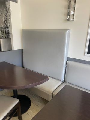 une table avec deux chaises et un banc dans un coin de la pièce