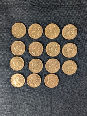 a close up of a pile of gold coins on a black surface