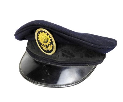 un chapeau noir orné d'un emblème représentant un lion doré