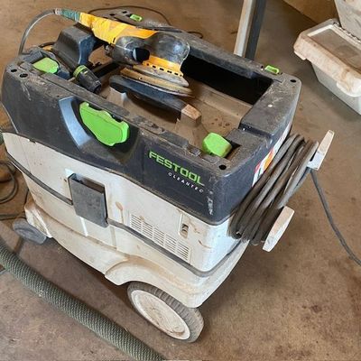 une photo d'un aspirateur sur lequel sont posés des outils