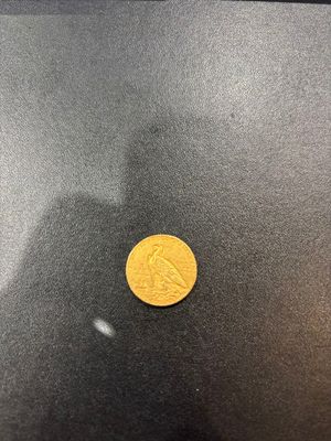 a close up of a gold coin on a black surface