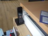 un téléphone portable posé sur une étagère à côté d'une bouteille d'eau