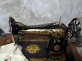 une vieille machine à coudre posée sur une table en bois