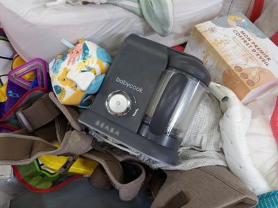 a baby in a stroller with a bottle and diaper next to it