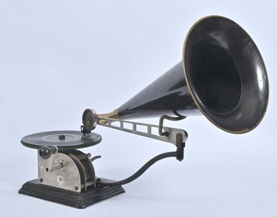 un vieux gramophone noir et argent posé sur un socle en bois