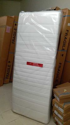 de nombreux cartons de matelas empilés par terre dans une pièce