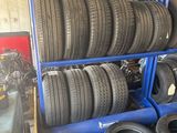 des pneus sont empilés sur un chariot bleu dans un garage