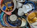 many cups and saucers sitting in a box together