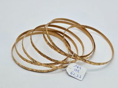 quatre bracelets rigides en or avec une étiquette sur laquelle est inscrit « Just go, girl »