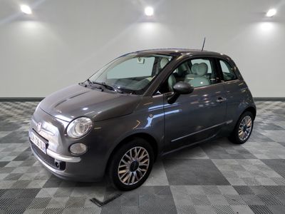 the small grey car is parked in the garage on a checkered floor