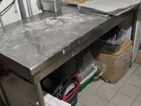 table de travail en acier inoxydable dans une cuisine professionnelle très encombrée