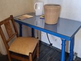 a blue table with a chair and a basket on it