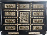a black and gold chest of drawers with ornate designs