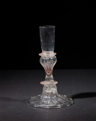 a glass candle holder that is sitting on a table