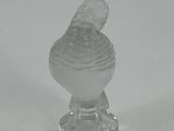 a clear glass bird figurine sitting on top of a glass base
