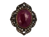 gros plan d'une bague avec une pierre rouge entourée de diamants