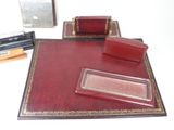 a red desk set with a pen, pencil, and erases