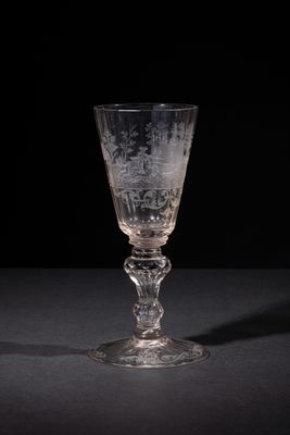 a wine glass sitting on a table with a black background