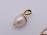 gold plated pearl pendant and earrings on a white surface