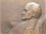 un gros plan sur une plaque en bronze représentant le visage d'un homme